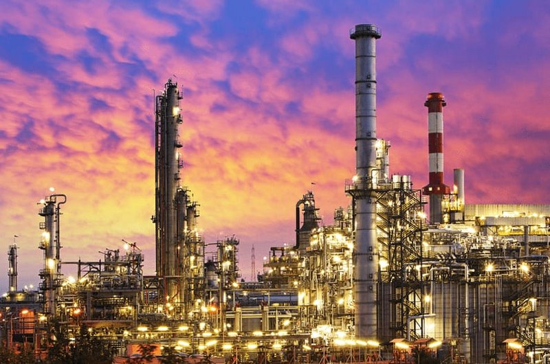 Industrial petroleum storage facility with large fuel tanks and pipelines in an African semi-desert environment.